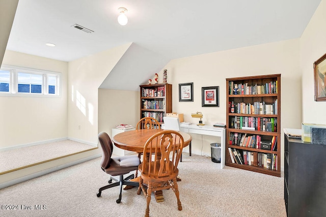 carpeted dining room with vaulted ceiling