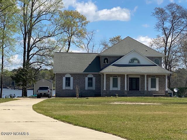 view of front of property with a front yard, a garage, and an outdoor structure