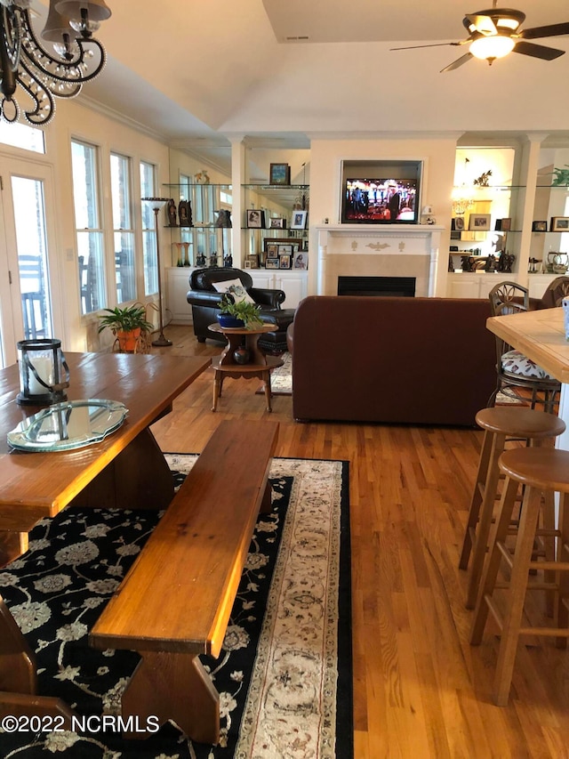 dining area with wood-type flooring, ceiling fan, and crown molding