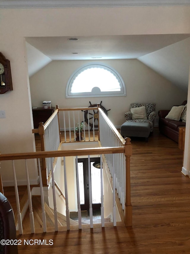 stairs featuring hardwood / wood-style floors and vaulted ceiling