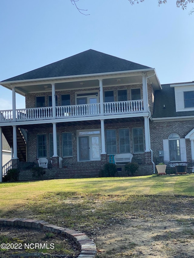 exterior space with a front yard and a balcony