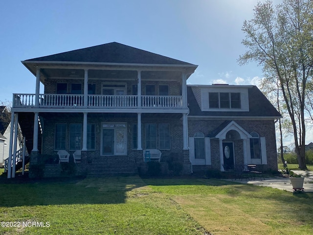 view of front of house featuring a front yard and a balcony