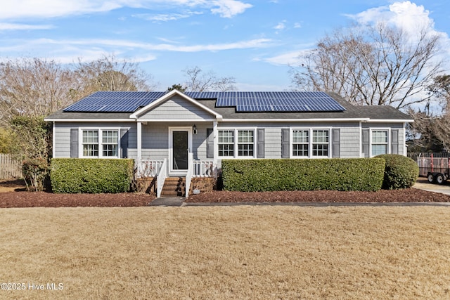 ranch-style house with a front yard and solar panels