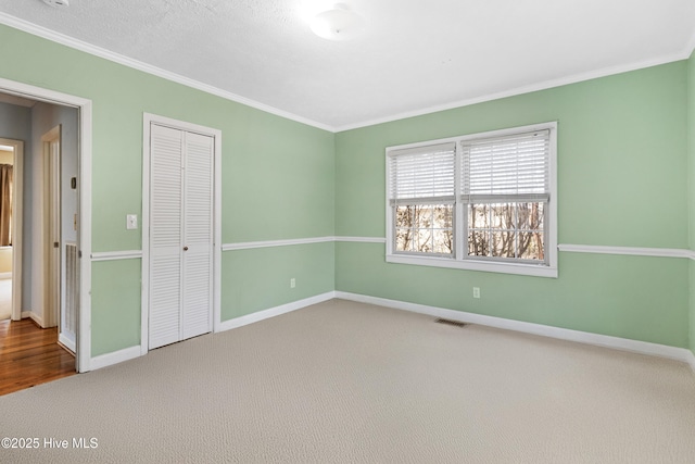 unfurnished room featuring crown molding and carpet