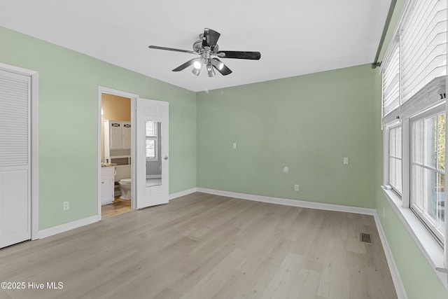 unfurnished bedroom with ceiling fan, connected bathroom, light hardwood / wood-style floors, and a closet