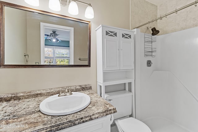 bathroom featuring vanity, ceiling fan, toilet, and a shower