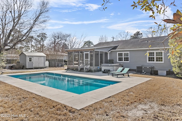 view of pool featuring a storage shed, a hot tub, a sunroom, cooling unit, and a patio