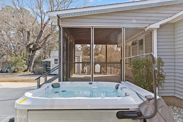 view of patio / terrace with a hot tub and a sunroom