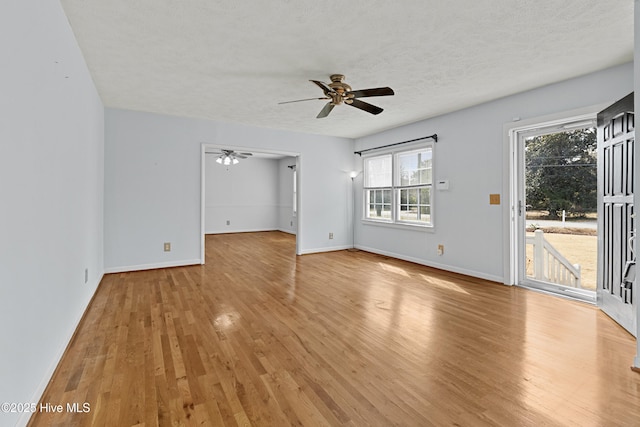 unfurnished room with ceiling fan, a textured ceiling, and light wood-type flooring