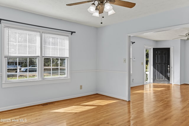 unfurnished room with ceiling fan, hardwood / wood-style flooring, a textured ceiling, and a healthy amount of sunlight