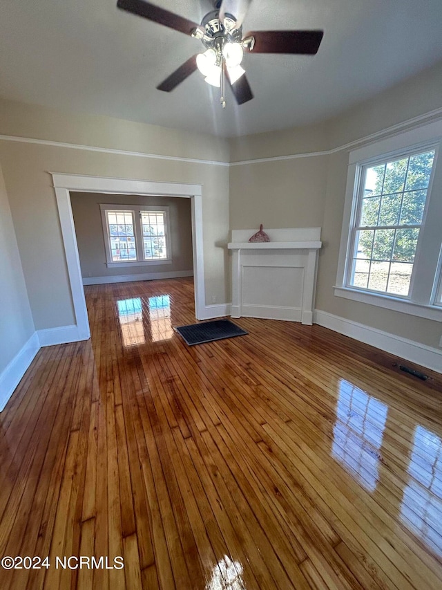 unfurnished living room with ceiling fan and hardwood / wood-style floors