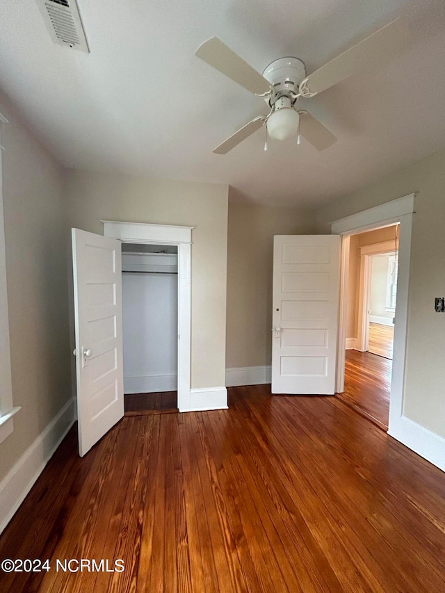 unfurnished bedroom featuring dark hardwood / wood-style flooring, a closet, and ceiling fan