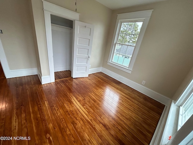 unfurnished bedroom featuring hardwood / wood-style flooring and a closet