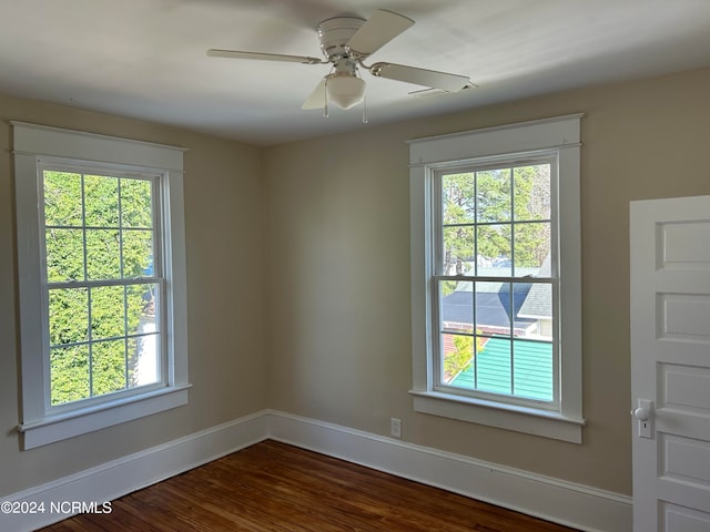 empty room featuring dark hardwood / wood-style floors, plenty of natural light, and ceiling fan