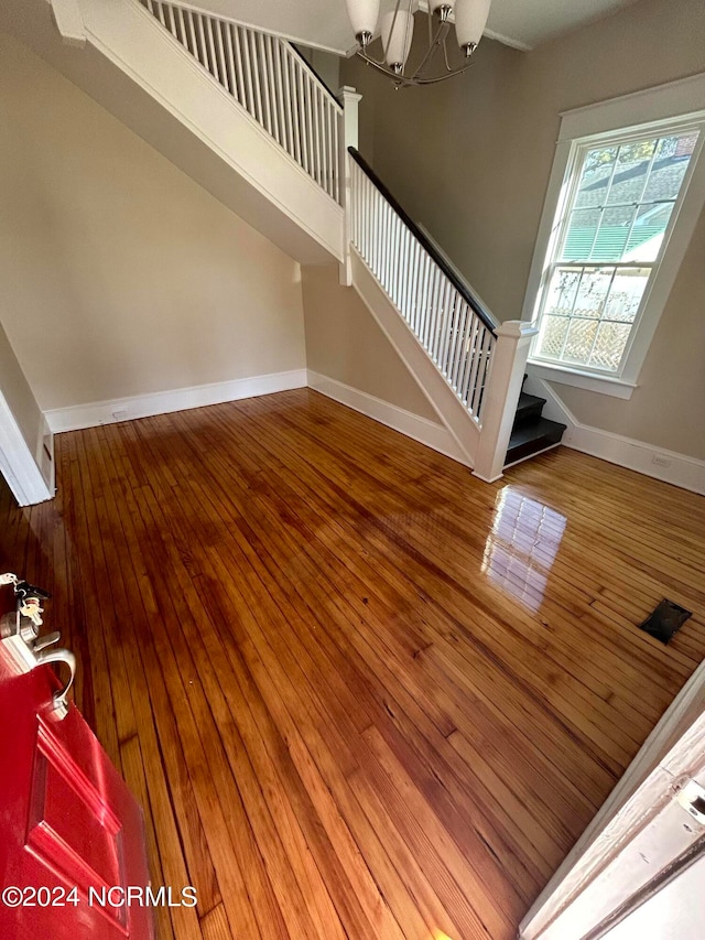 staircase with an inviting chandelier and hardwood / wood-style flooring