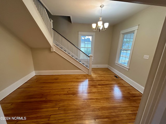 foyer entrance featuring hardwood / wood-style floors and a chandelier