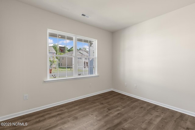 unfurnished room with dark hardwood / wood-style flooring