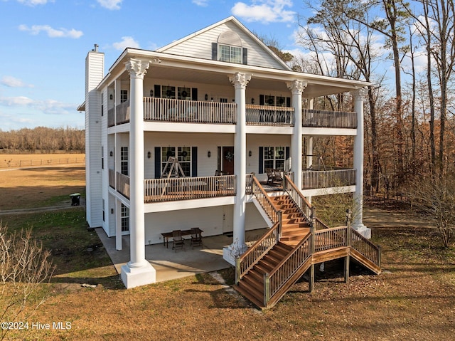 back of house with a lawn and a patio area