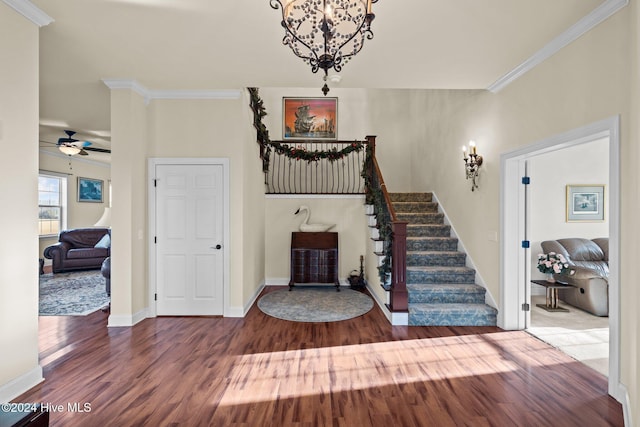 entrance foyer featuring wood-type flooring, ceiling fan with notable chandelier, and ornamental molding