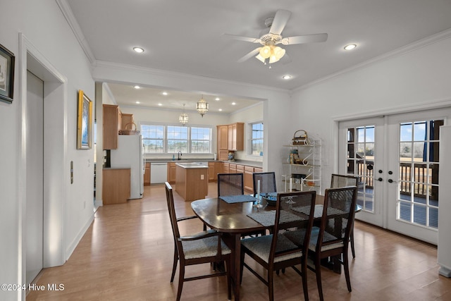 dining area with sink, french doors, light hardwood / wood-style floors, ceiling fan with notable chandelier, and ornamental molding