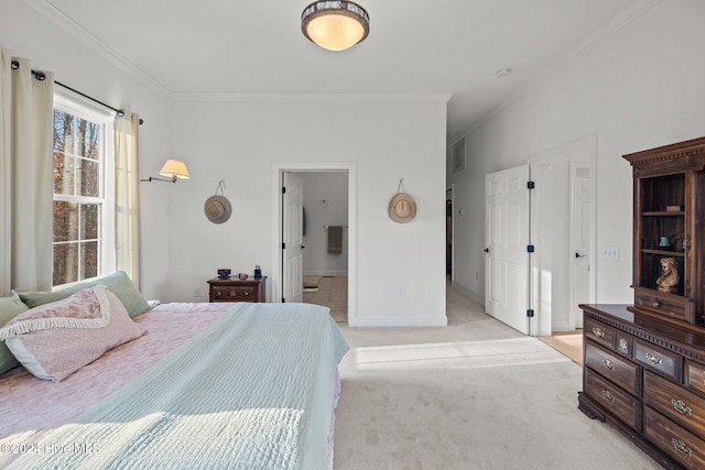 carpeted bedroom with ensuite bath and ornamental molding