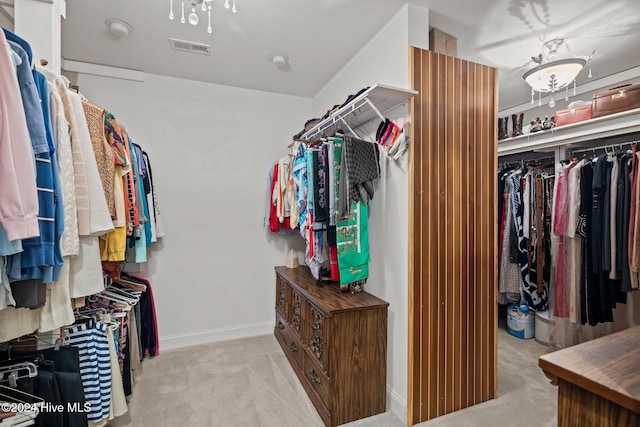 spacious closet featuring light colored carpet