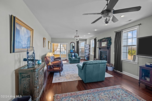 living room with ceiling fan and dark wood-type flooring