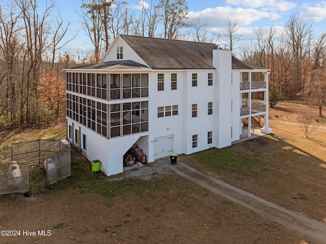 view of home's exterior with a garage and a sunroom