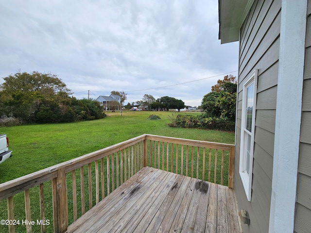 wooden terrace featuring a lawn