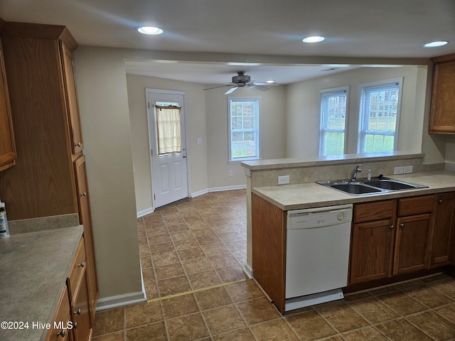 kitchen with kitchen peninsula, white dishwasher, a healthy amount of sunlight, and sink