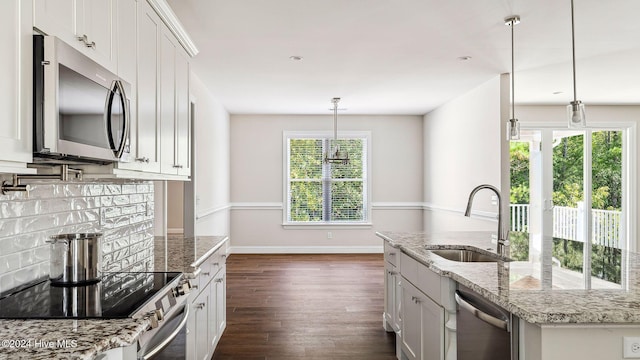 kitchen with white cabinets, decorative light fixtures, sink, and appliances with stainless steel finishes