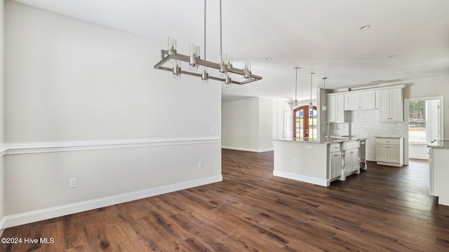 kitchen with pendant lighting, a healthy amount of sunlight, sink, and a kitchen island with sink