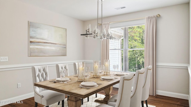 dining space with wood-type flooring and a notable chandelier