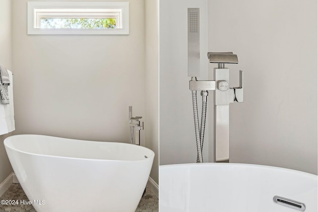 bathroom with a washtub and tile patterned flooring