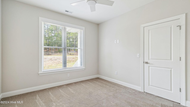 unfurnished room featuring ceiling fan and light carpet