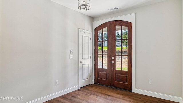 entryway with plenty of natural light, an inviting chandelier, wood-type flooring, and french doors