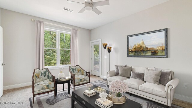 carpeted living room with ceiling fan