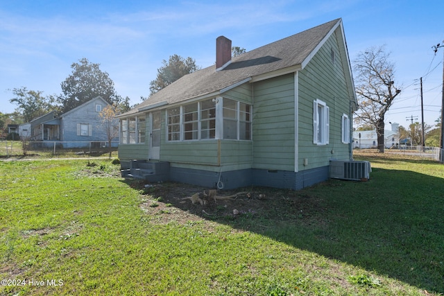 view of side of property featuring a yard and cooling unit