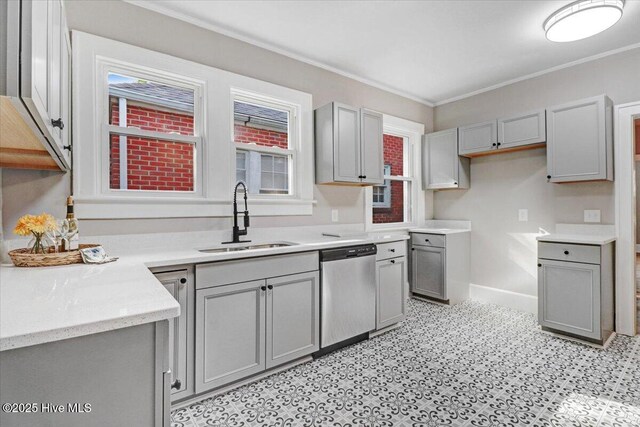 kitchen featuring a sink, dishwasher, baseboards, gray cabinetry, and ornamental molding