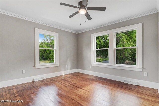 empty room with visible vents, ornamental molding, and a healthy amount of sunlight