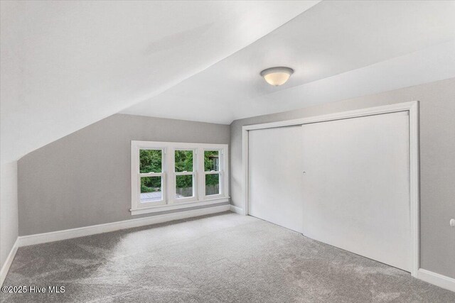 bonus room with carpet floors, baseboards, and lofted ceiling
