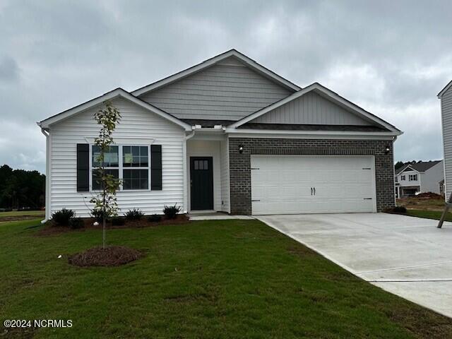 view of front of house with a garage and a front lawn