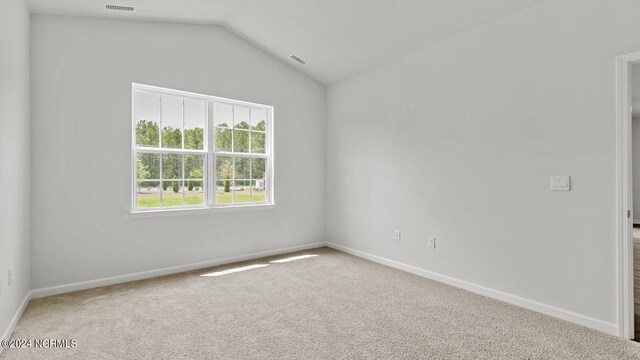 unfurnished room with carpet and lofted ceiling