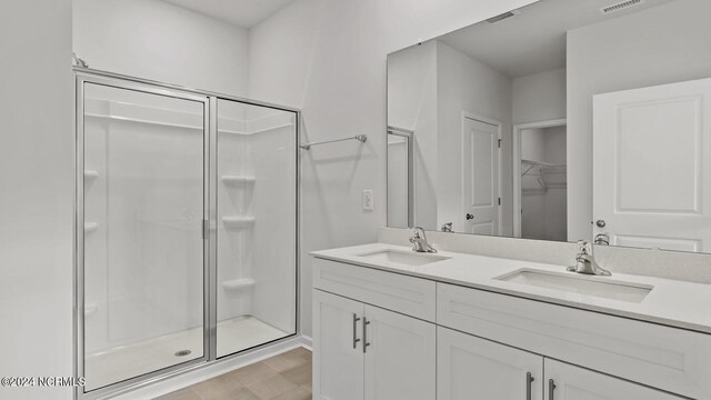 bathroom with a shower with door, vanity, and hardwood / wood-style flooring