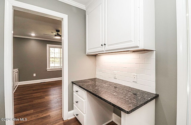 kitchen featuring dark wood-type flooring, white cabinets, crown molding, ceiling fan, and tasteful backsplash