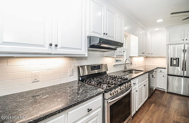 kitchen with dark wood-type flooring, white cabinets, sink, ornamental molding, and stainless steel appliances