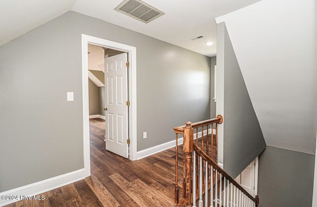 corridor with dark wood-type flooring and lofted ceiling