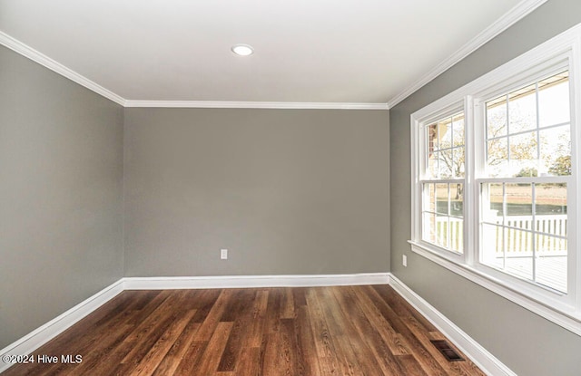 spare room featuring dark wood-type flooring and ornamental molding