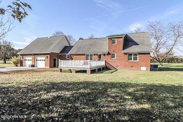 rear view of property with a yard, a garage, and a deck