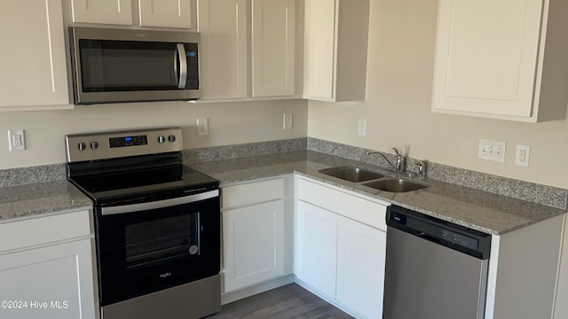 kitchen featuring white cabinetry, sink, stainless steel appliances, and light stone counters